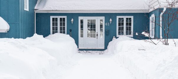 image of a blue house in several feet of snow